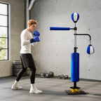 Sportininkas boksuoja mėlyną bokso stovą sporto salėje su treniruokliais fone