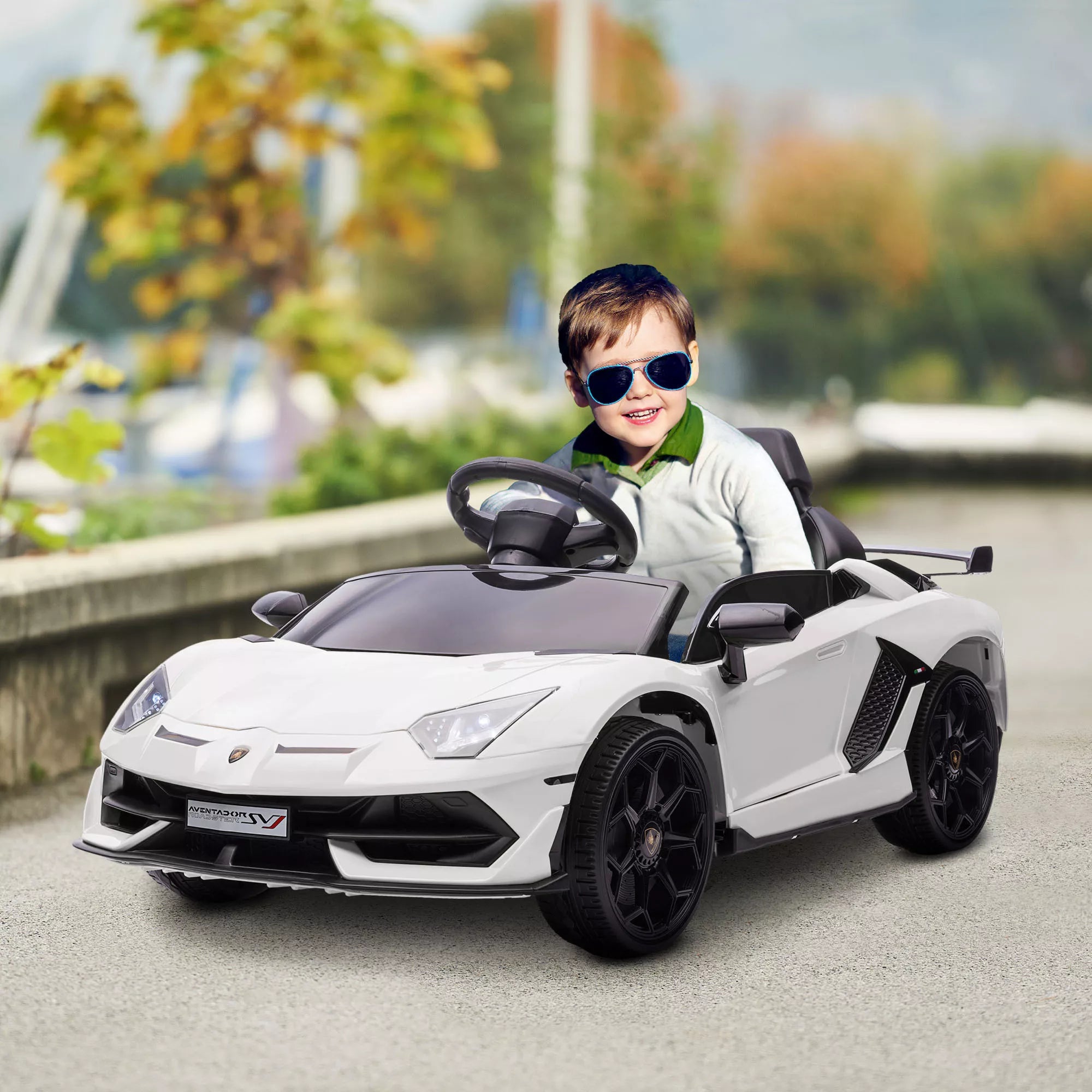Vaikas sėdi baltame elektromobilyje lauke
