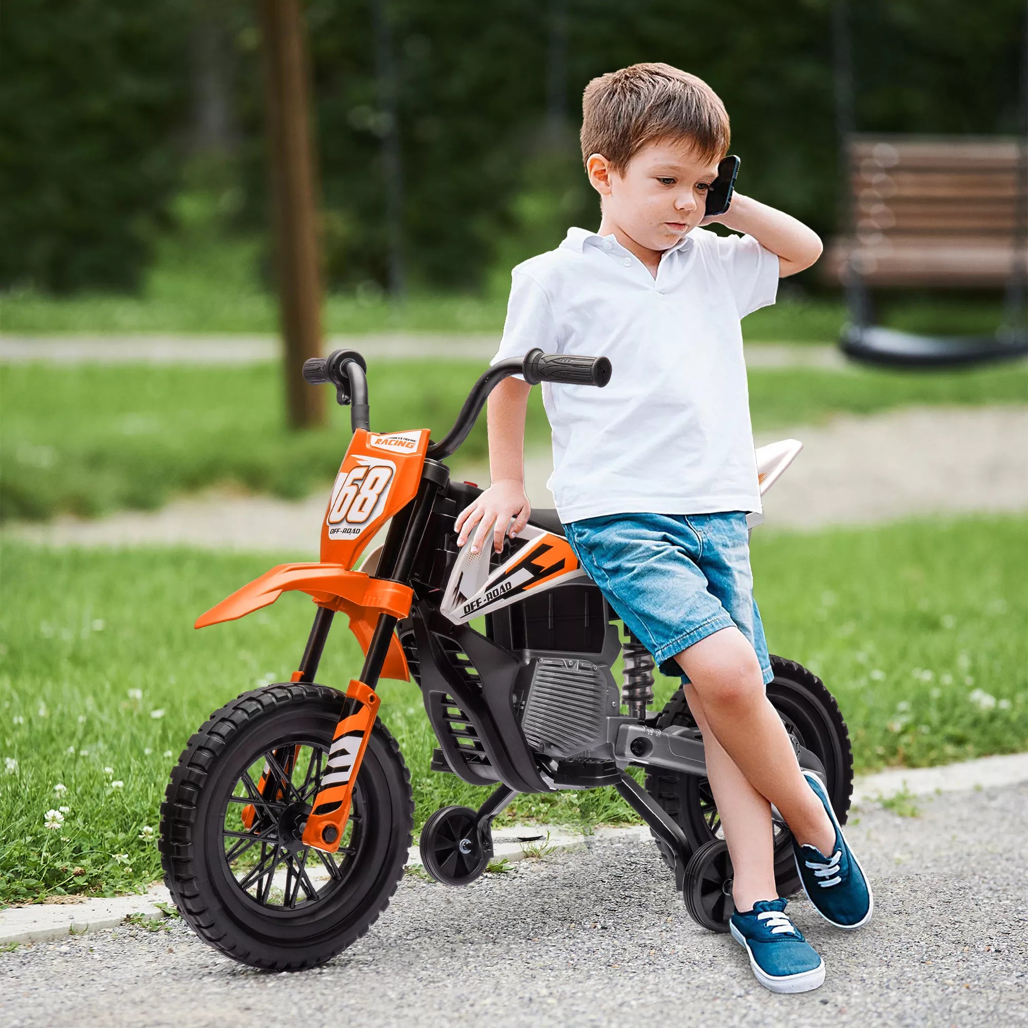 Berniukas sėdi ant oranžinio elektrinio motociklo