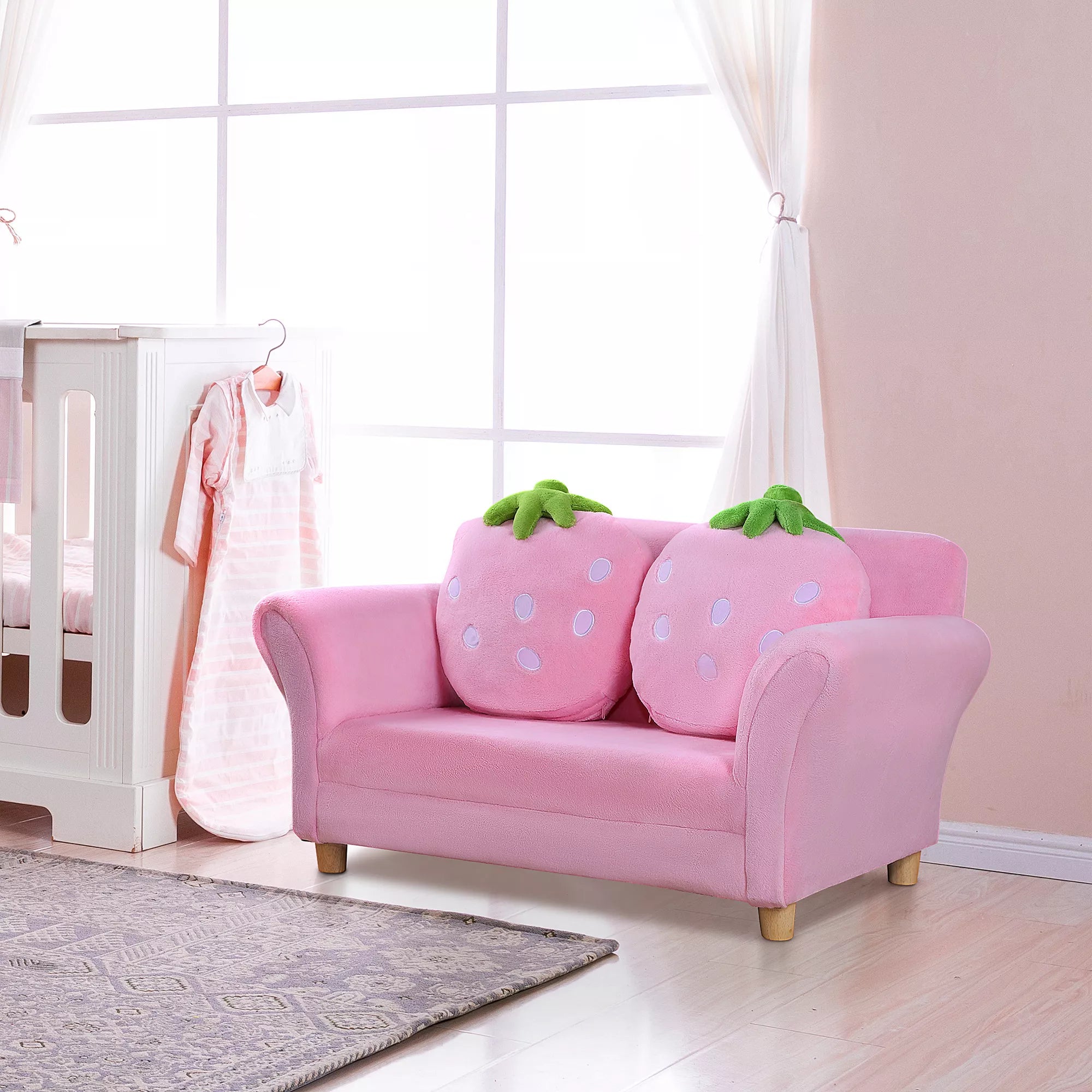 Rožinė vaikiška sofa su braškės pagalvėlėmis vaikų kambaryje