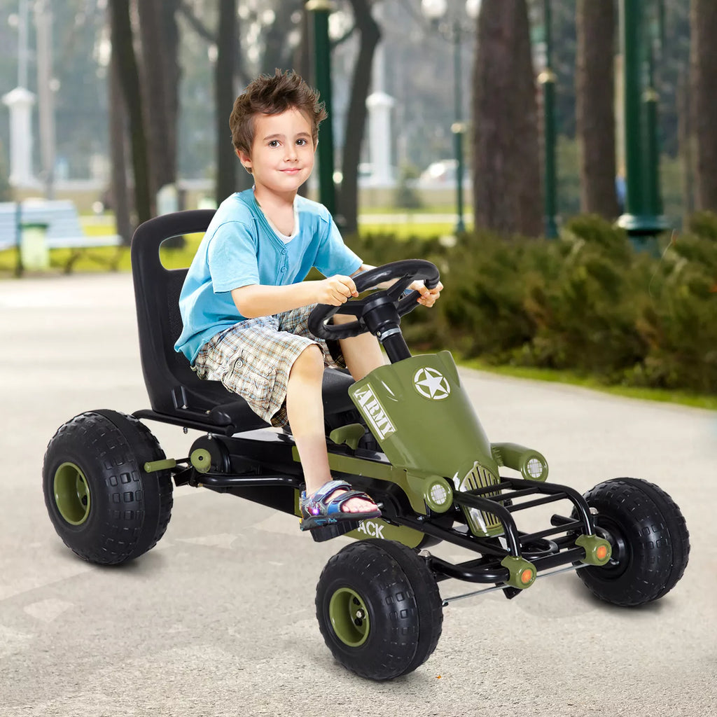 Berniukas važiuoja žaliu pedaliniu go-kart automobiliu lauke