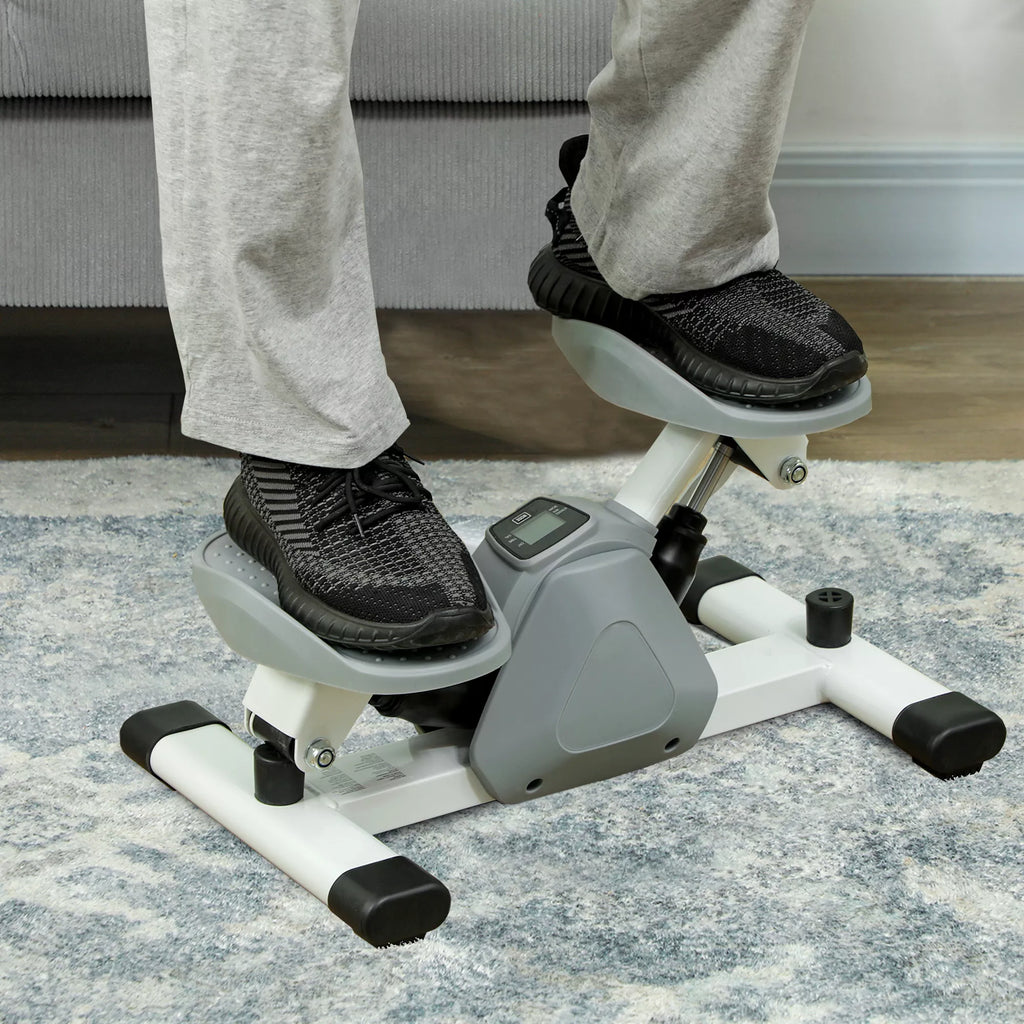 Kojos ant pilko mini steperio pedalų iš arti