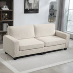 Kreminė ryšeliuoto audinio sofa svetainėje prie knygų spintos
