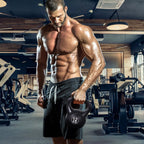 Raumeningas vyras sporto salėje laiko juodą kettlebell svorį rankoje
