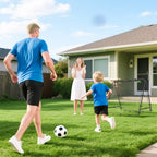 Vyras su vaiku žaiždia futbolą prie tinklo