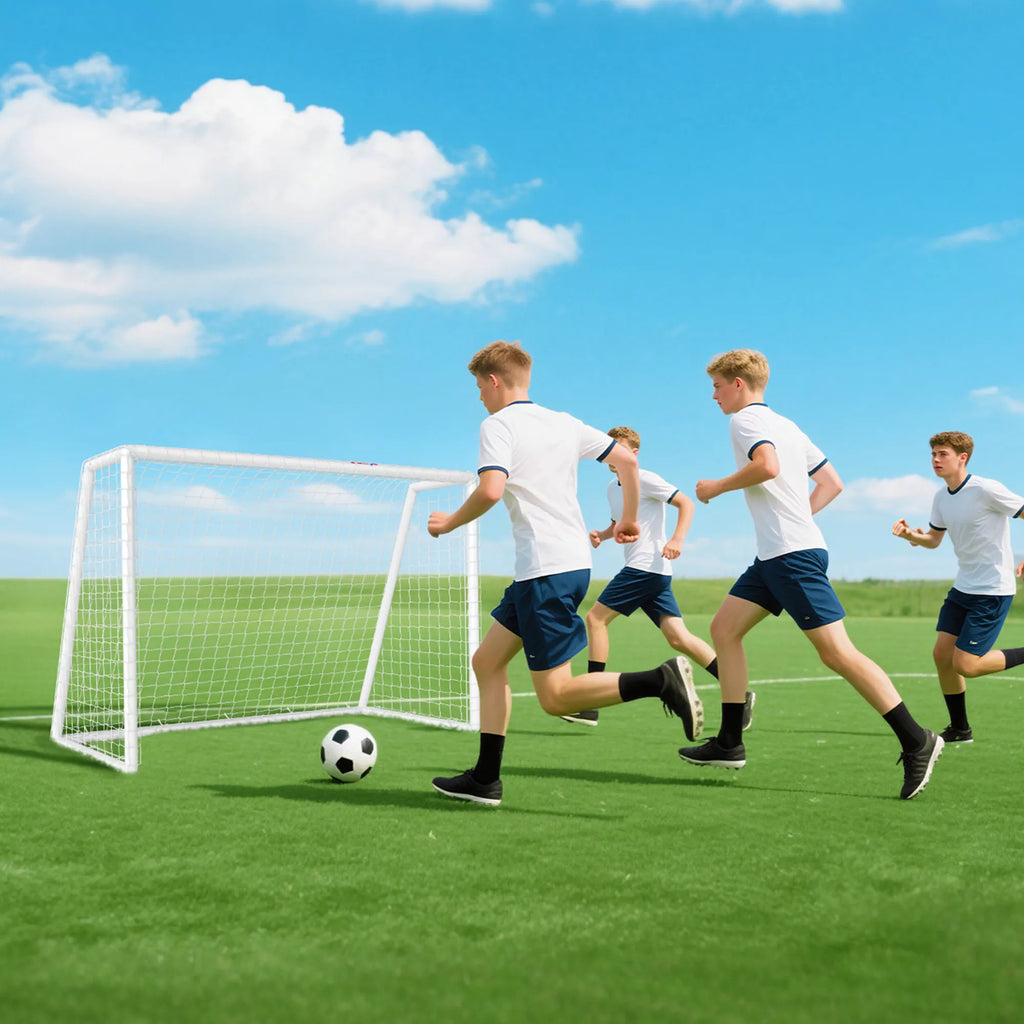 Vaikinai žaidžia futbolą prie vartų pievoje
