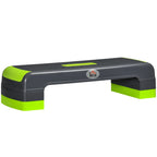 Pilka aerobikos pakyla su žaliais reguliuojamo aukščio blokeliais