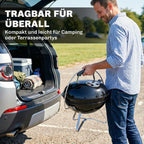 Vyras neša kepsninę už rankenos šalia automobilio bagažinės