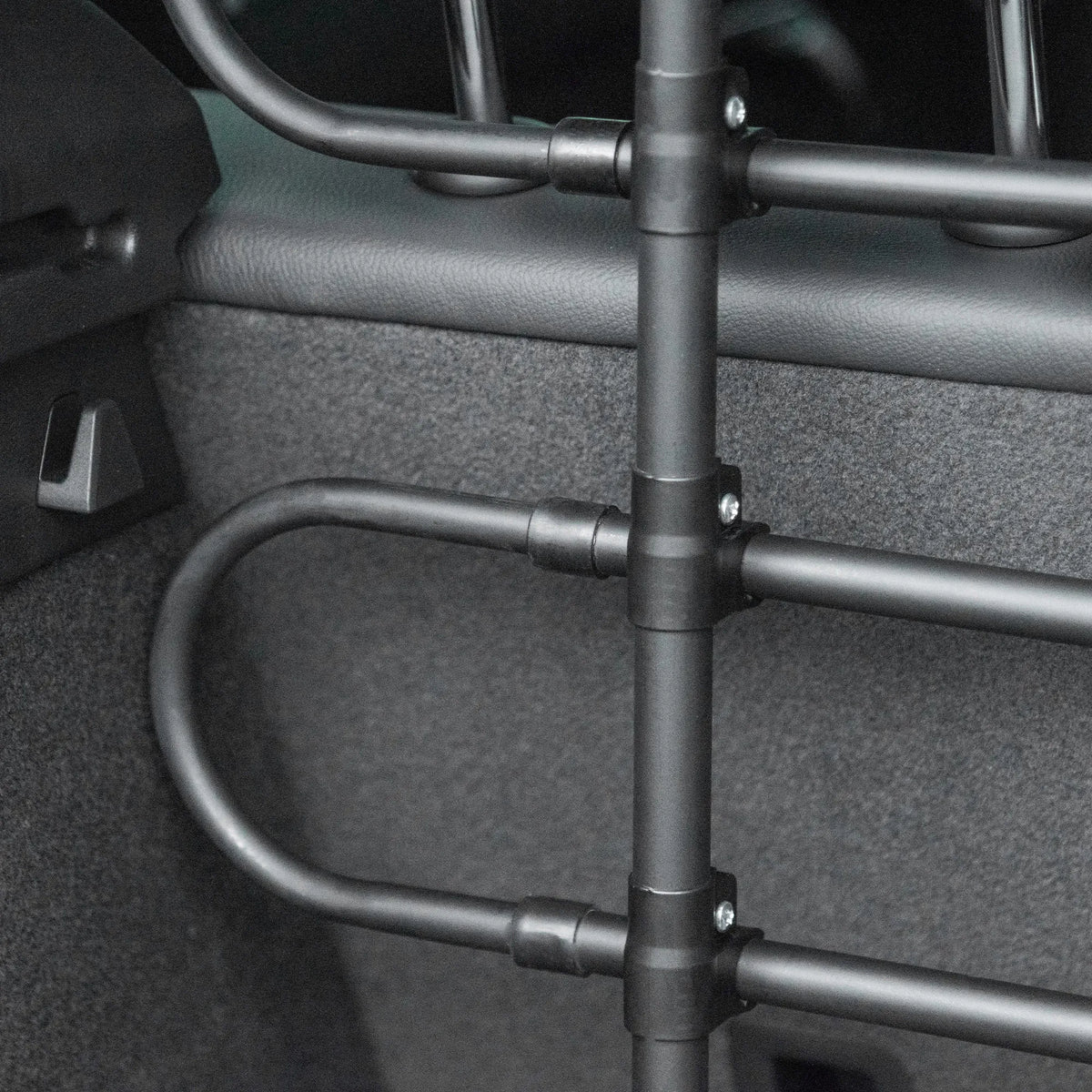 Grotelių tvirtinimo prie automobilio šono detalė iš arti, matomas varžtas
