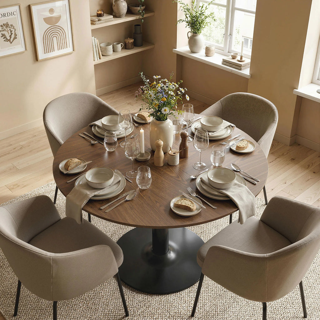 Keturios minkštos smėlio spalvos kėdės aplink apvalų rudą stalą