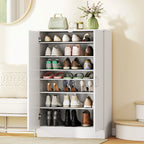 Atidaryta batų spintelė su įvairia avalyne, ant viršaus rankinė ir gėlių puokštė