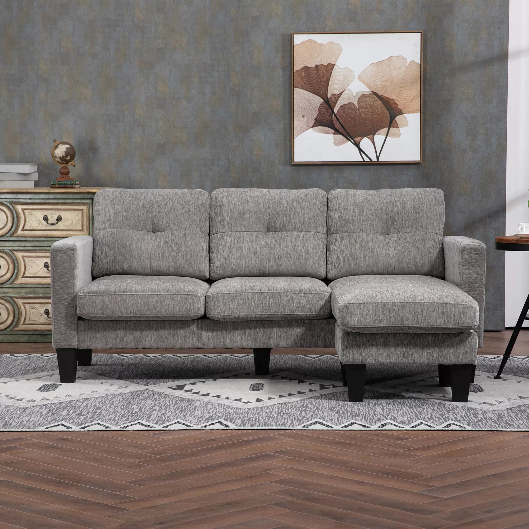 Pilka L formos kampinė sofa kambaryje