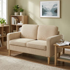 Smėlio spalvos sofa svetainėje su paveikslu ir knygų lentyna