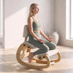 Meditacijos poza sėdint ergonominėje supamoje kėdėje šviesiame kambaryje