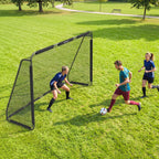 Žmonės žaidžia futbolą parke šalia didesnių vartų su tinkleliu