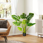 Dirbtinė monstera šviesiame kambaryje prie lango