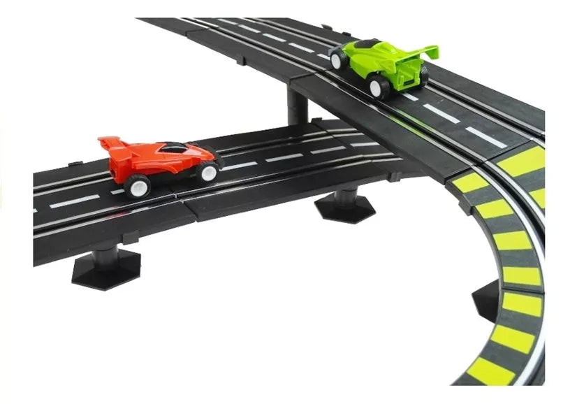 Dviejų lygių trasos tiltelis su raudonu automobiliuku apačioje ir žaliu viršuje