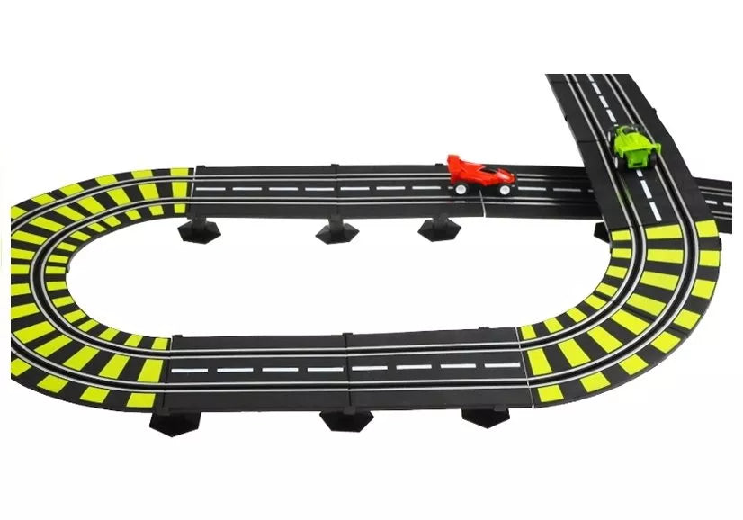 Ovalios trasos dalis iš viršaus su raudonu ir žaliu automobiliukais prie sankirtos