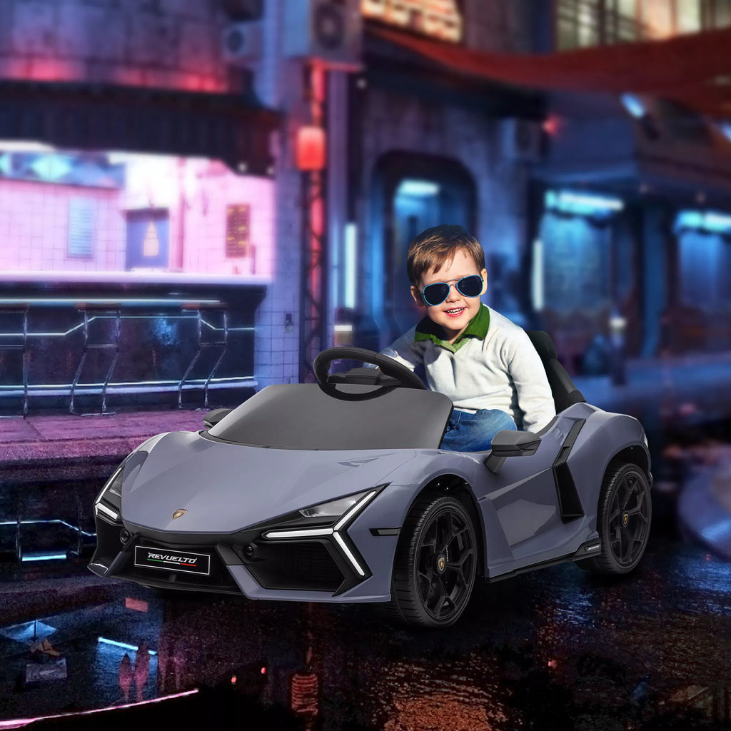Berniukas važiuoja pilku elektriniu Lamborghini automobiliu