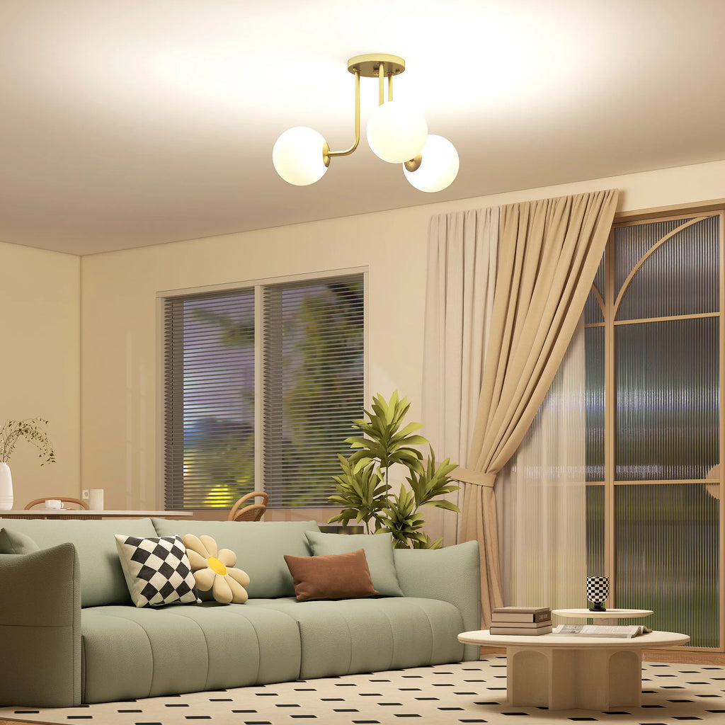 Vakarą svetainėje su žalia sofa šviečia auksinis šviestuvas
