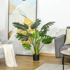 Dirbtinė monstera svetainėje prie paveikslo ir sofos