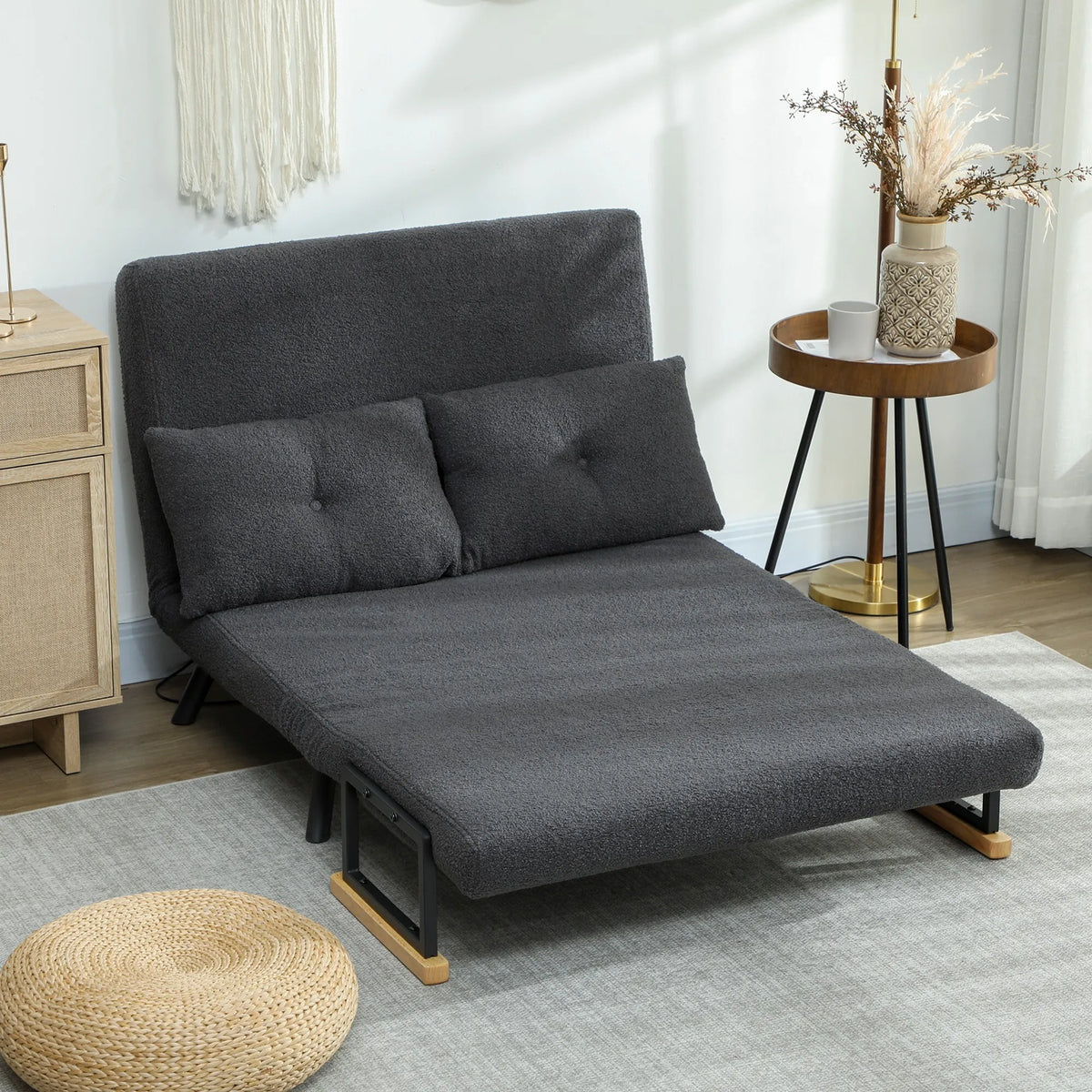 Tuščia sulankstyta sofa lova svetainėje šalia stalelio su gėlėmis
