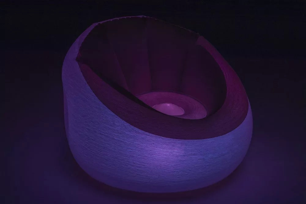 Pripučiamas fotelis tamsoje švyti sodria violetine spalva