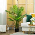 Žalia dirbtinė Areca palmė prie sofos