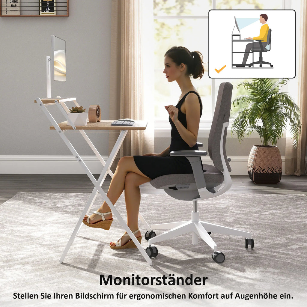 Moteris sėdi prie stalo su monitoriumi pastatytu ant stovo