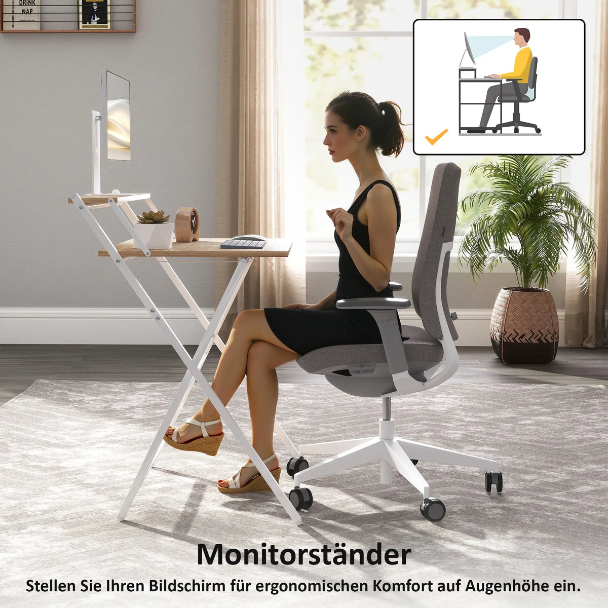Moteris sėdi prie stalo su monitoriumi pastatytu ant stovo