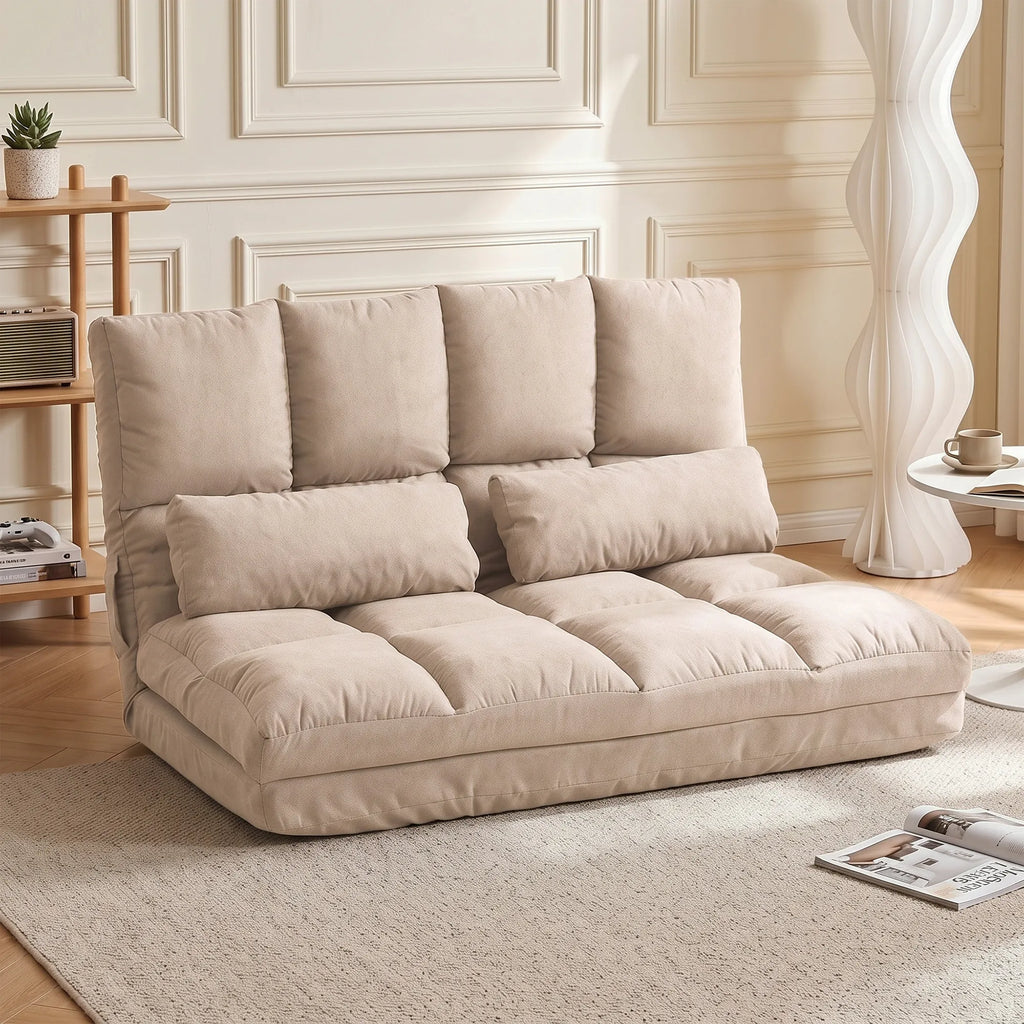 Grindų sofa-lova svetainėje šalia gėlės vazono ir lempos