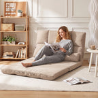 Gulto padėtyje išskleista sofa-lova, moteris skaito žurnalą prie lentynos