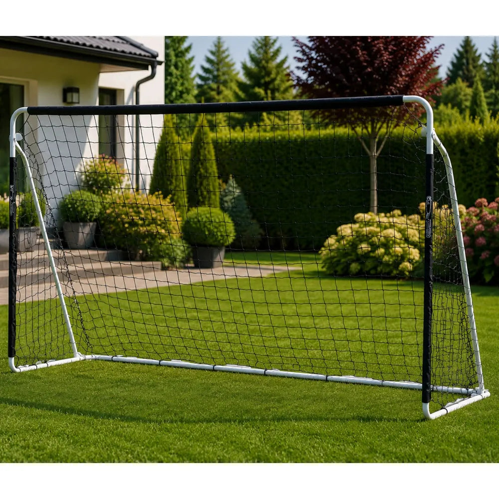 Futbolo vartai pastatyti sodo kieme prie krūmų ir gyvatvorės