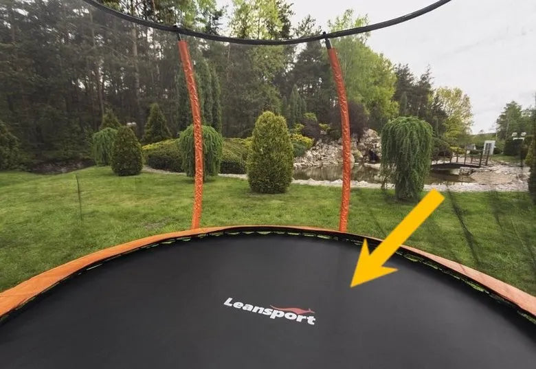 Trampolino kilimėlis sumontuotame lauko batute sodo aplinkoje