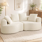 Kreminės spalvos sofa jaukioje svetainėje šalia toršero ir komodos