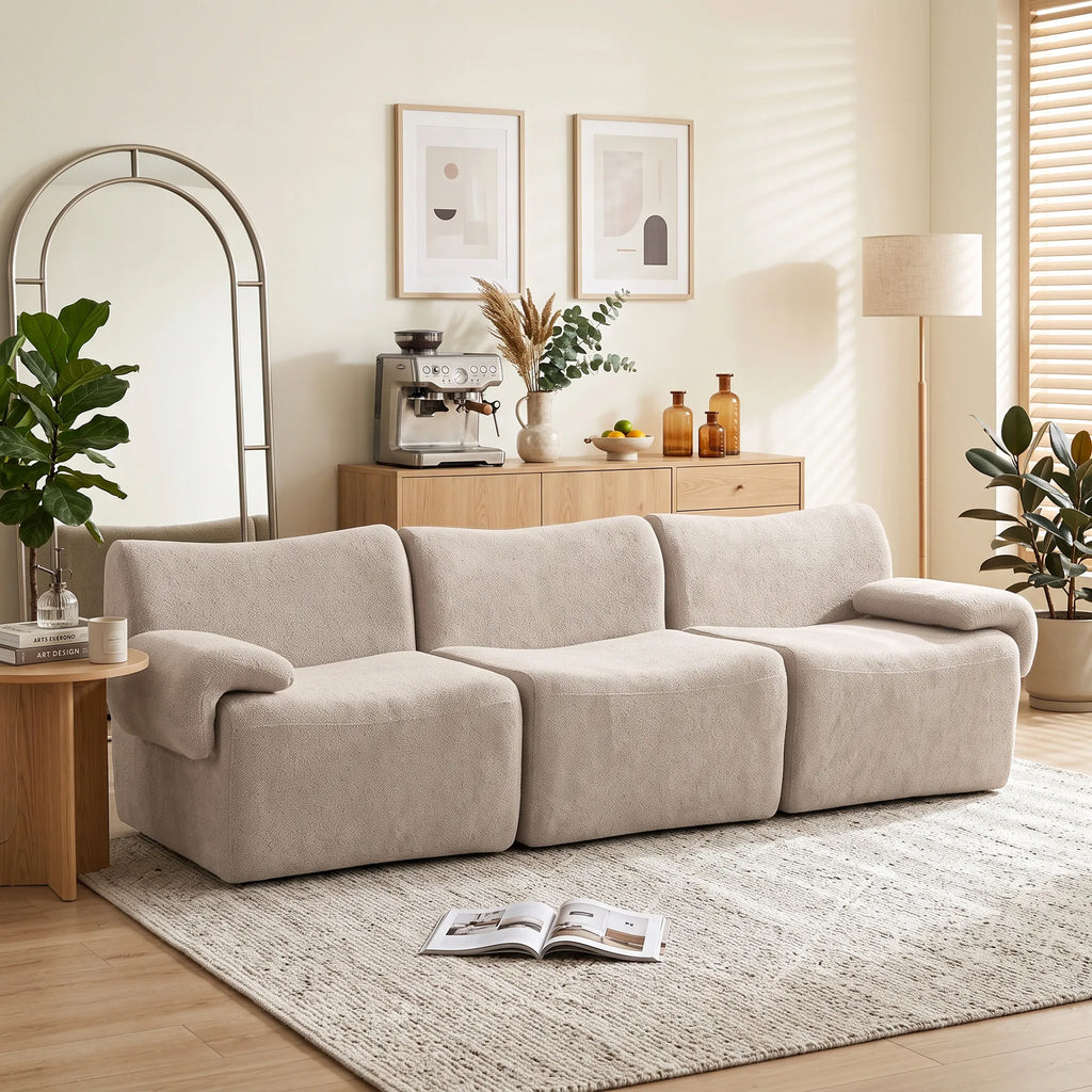 Svetainėje su veidrodžiu ir kavos aparatu stovi smėlio spalvos sofa