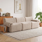 Prie medinės spintelės ir augalo įrengta smėlio spalvos šenilio sofa