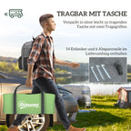 Vyras neša palapinės krepšį stovyklavietėje prie automobilio