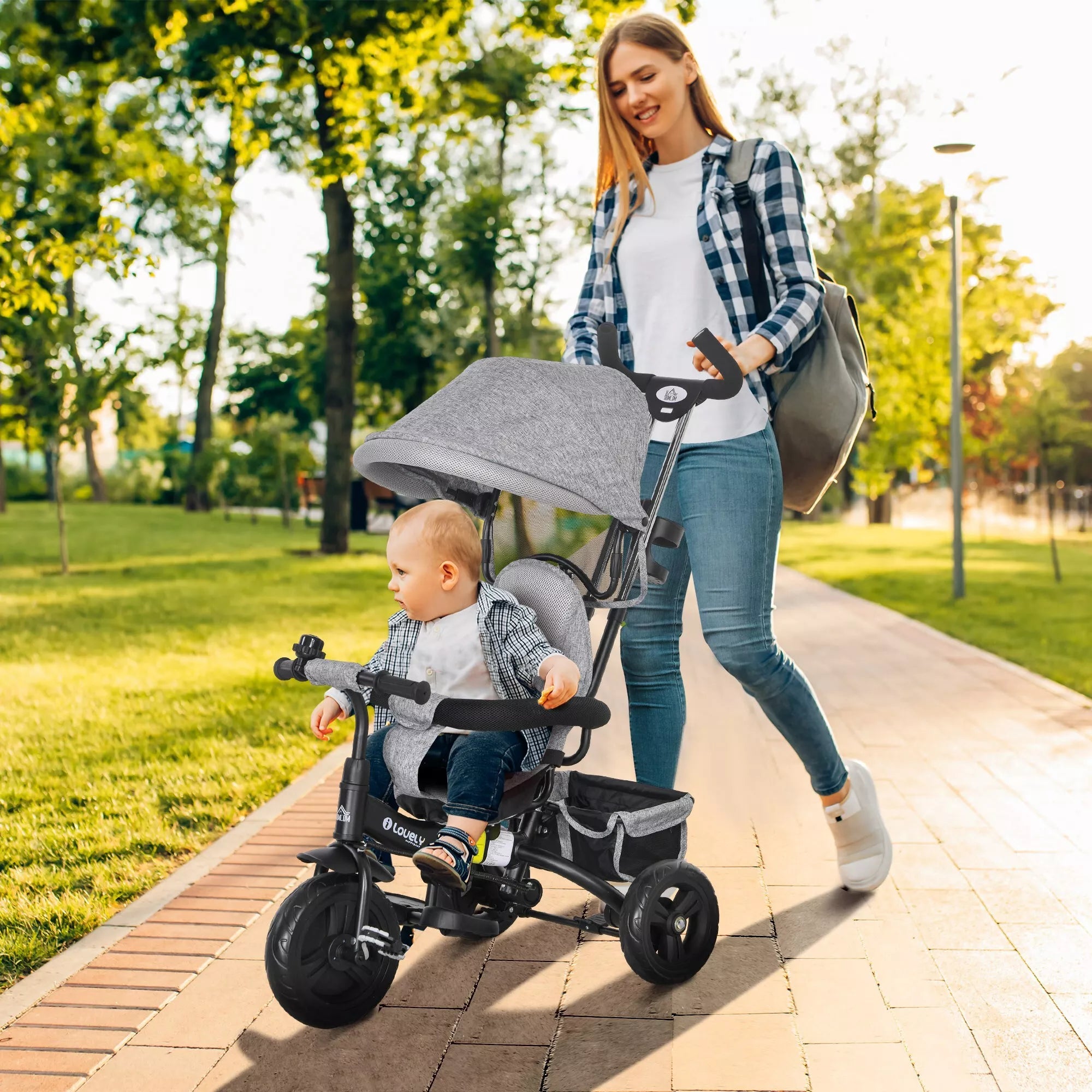 Pilkas vaikų triratis su mama ir vaiku parke