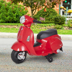 Vespa elektromobilis pastatytas kieme prie rudeninių lapų