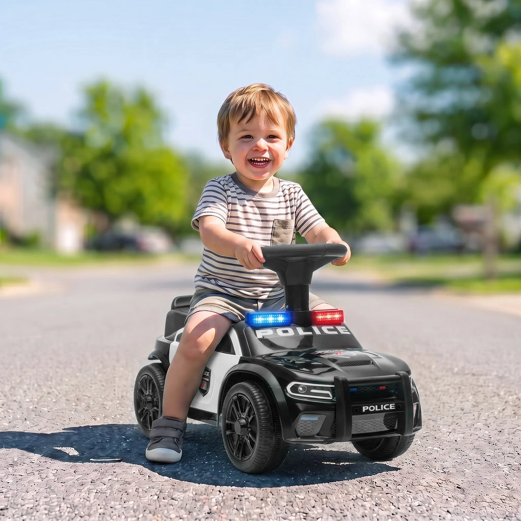 Besijuokiantis berniukas vairuoja paspiriamąjį automobilį gatvėje
