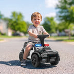 Besijuokiantis berniukas vairuoja paspiriamąjį automobilį gatvėje