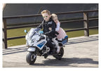 Du vaikai važiuoja vaikišku motociklu ant medinio tilto