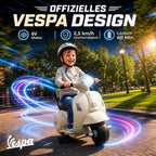 Berniukas su šalmu sėdi ant vaikiško Vespa stiliaus motociklo
