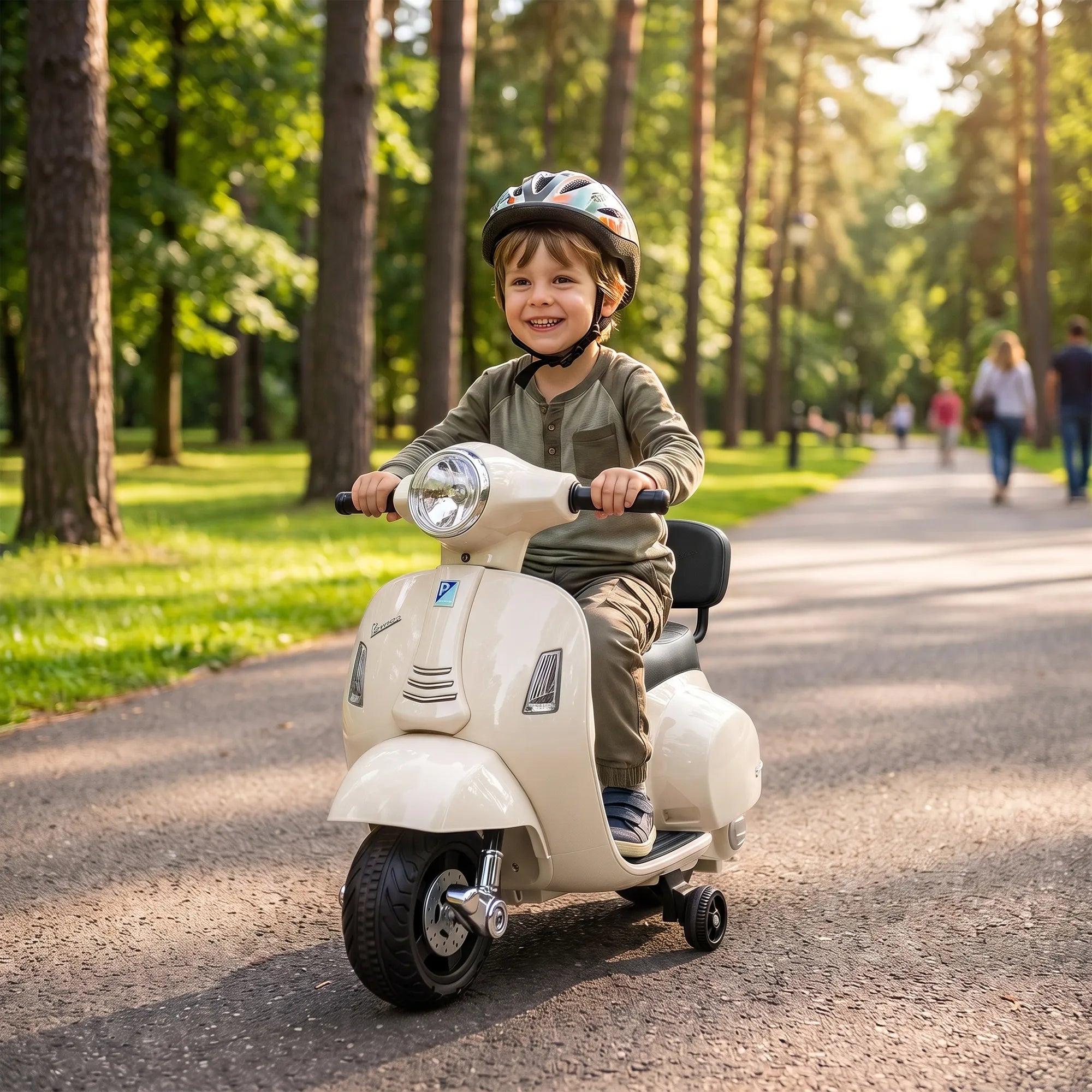 Berniukas su šalmu važiuoja vaikišku elektriniu motociklu parke