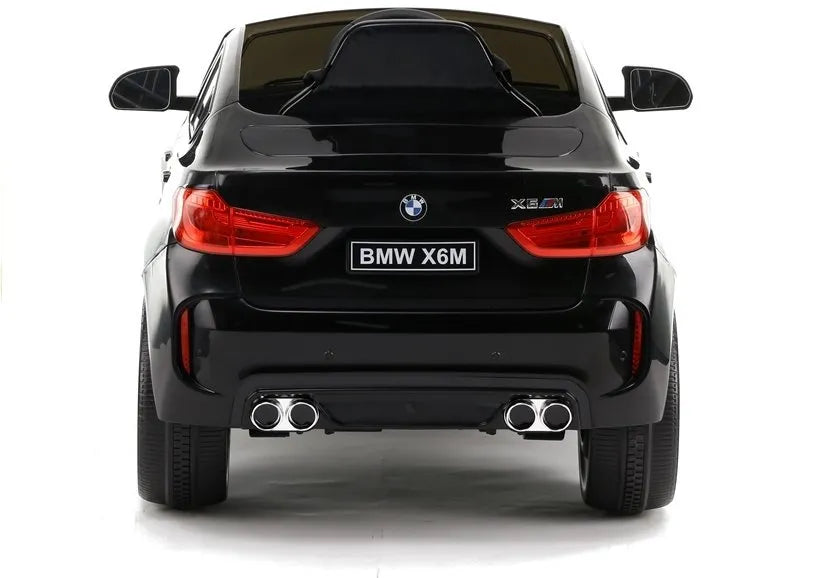 Juodo elektromobilio BMW X6M galinė dalis su žibintais ir numeriu