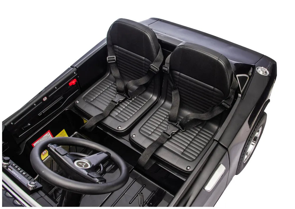 Dvi sėdynės su saugos diržais vaizduojamos iš viršaus vaikiškame elektromobilyje