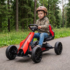Šalmą dėvintis berniukas vairuoja raudoną kartingą miško takeliu