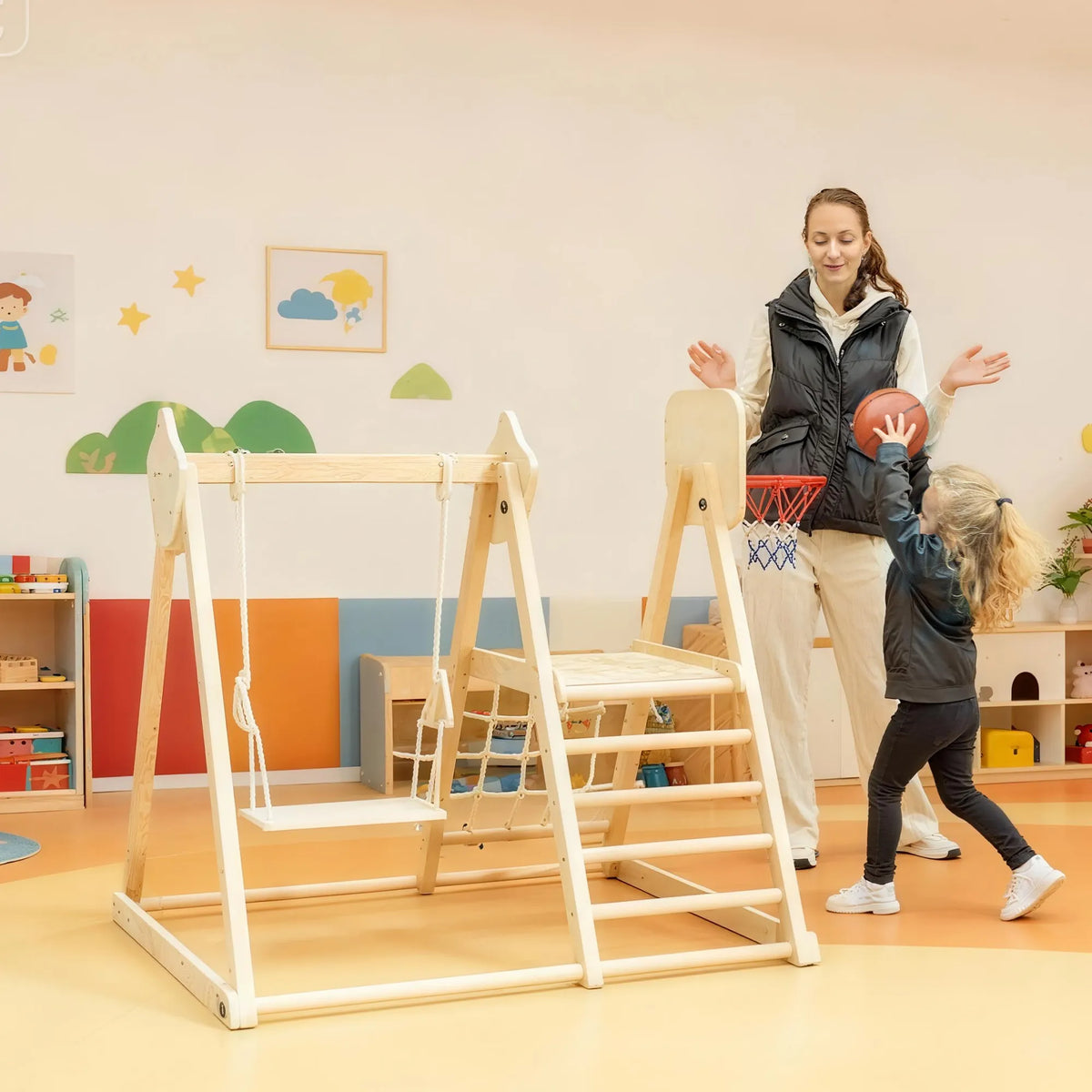 Mergaitė žaidžia krepšinį su mama spalvingame žaidimų kambaryje