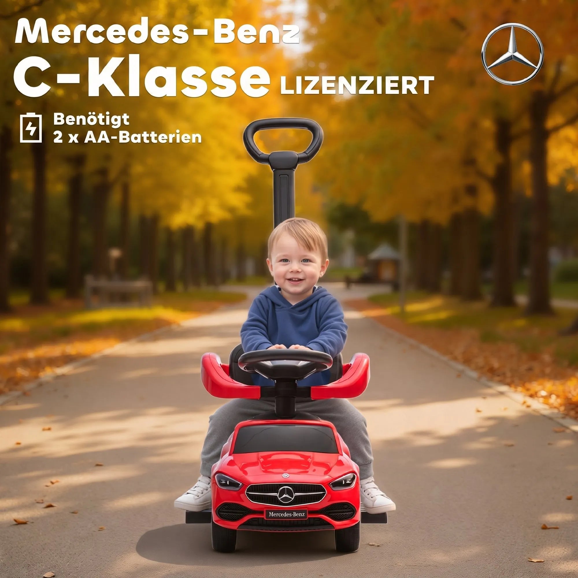 Berniukas sėdi raudoname automobiliuke rudenišką dieną parke